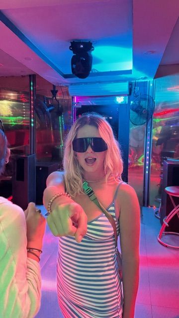 Crew member dancing under colorful party lights on board