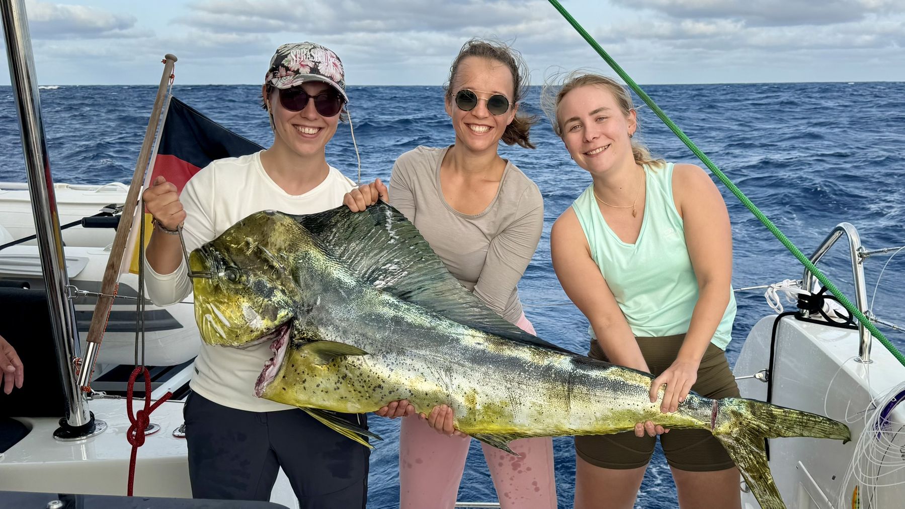 Crew holding a large mahi-mahi caught trolling behind Laurelli