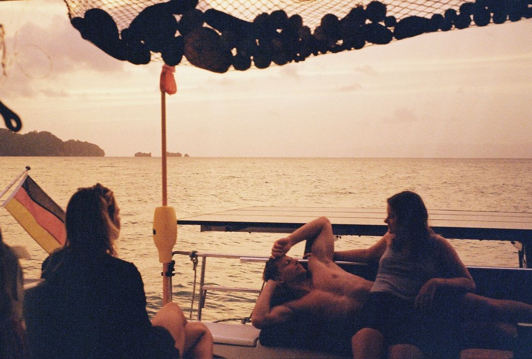 Crew relaxing on the stern at sunset under the German flag