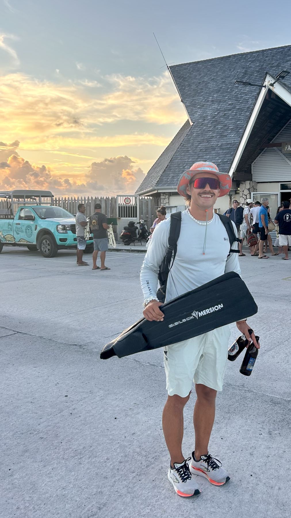 Felix with freediving fins and beers at sunset
