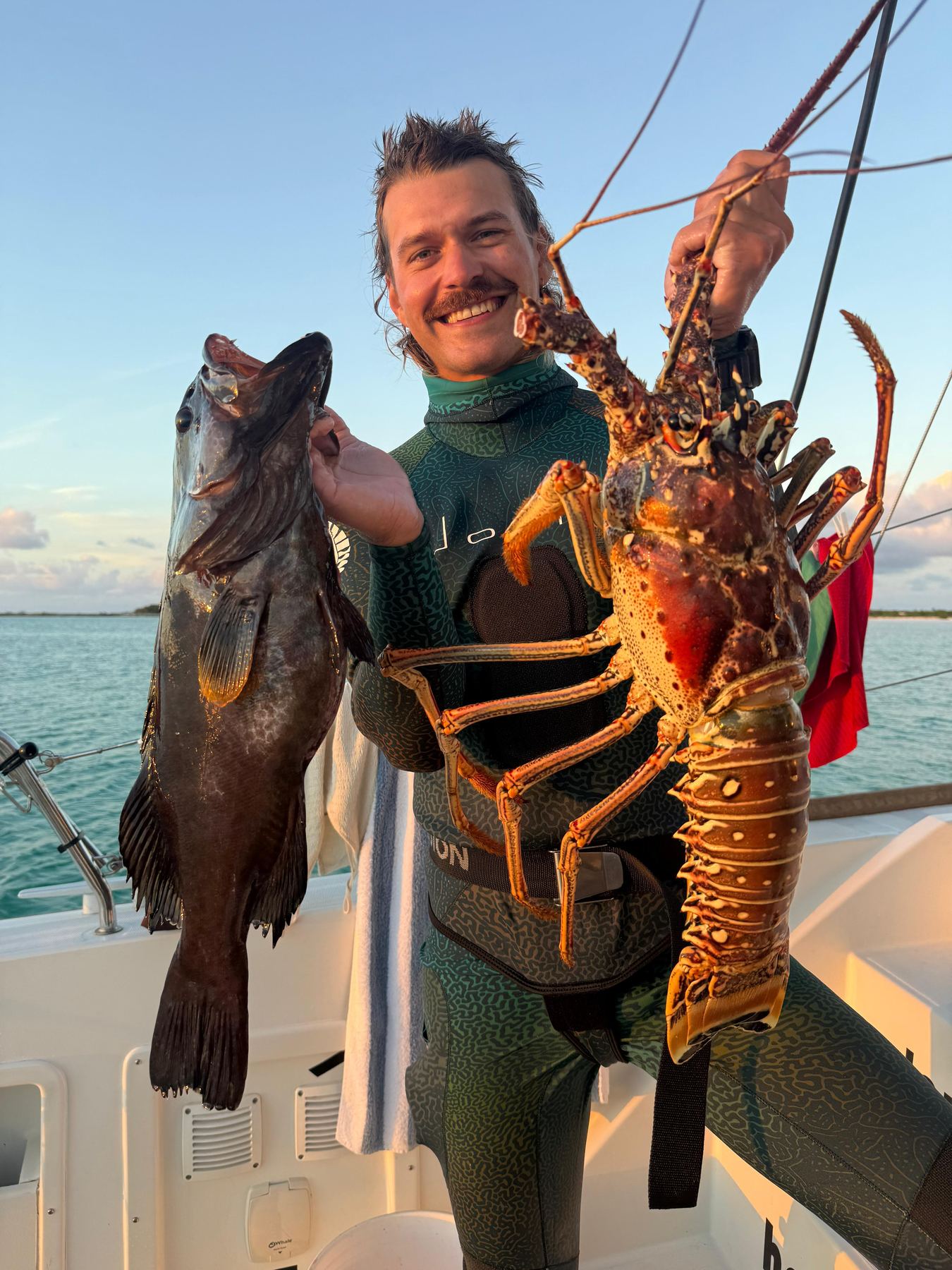 Felix holding a freshly caught fish and lobster